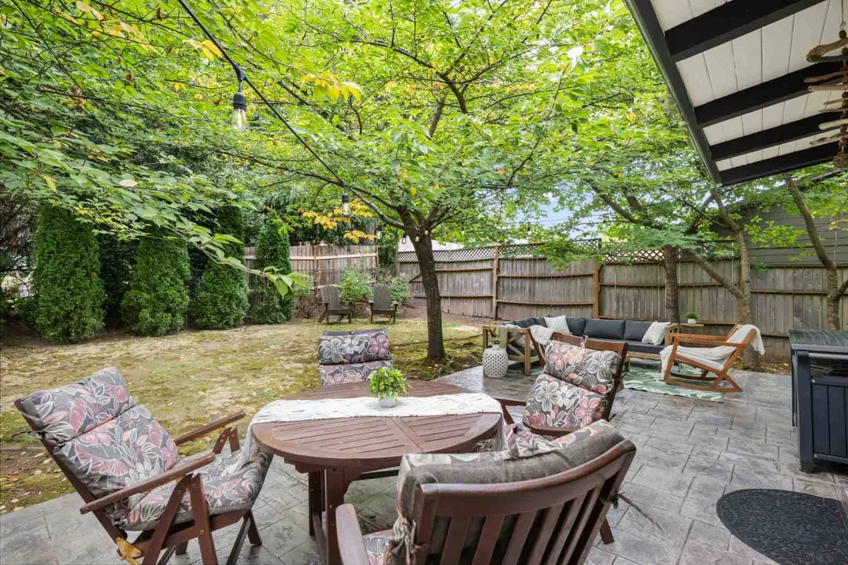 A cozy outdoor dining space featuring a wooden table surrounded by comfortable seating and lush greenery, accented with decorative touches that enhance the ambiance. The setting is tranquil, inviting, and perfectly suited for enjoying meals or relaxing while being immersed in nature.
