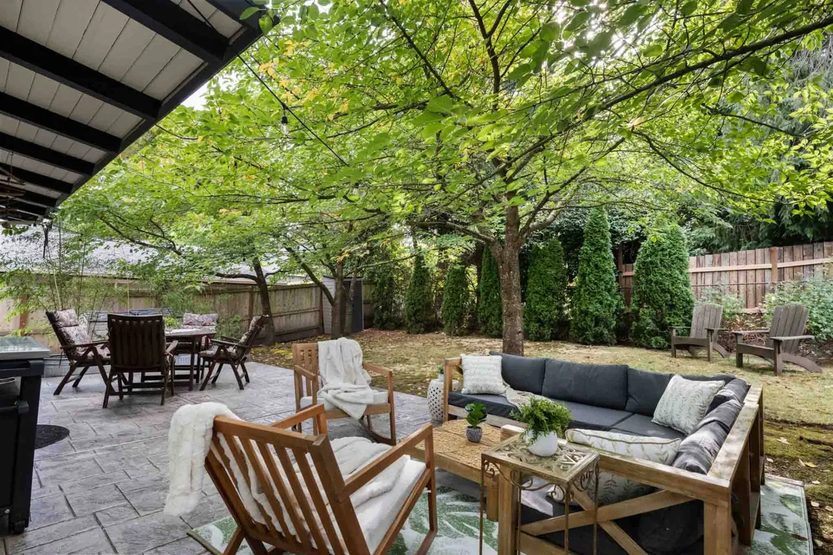 A comfortable outdoor seating area with a dining table surrounded by lush greenery and decorative plants, perfect for relaxing or enjoying meals outside. The area is calm and inviting, with the potential for sunset views and stargazing, suggesting a great spot for breaks between work sessions.