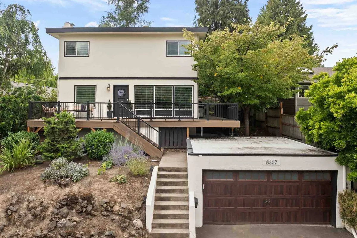 The front entrance and deck of the home, showcasing well-manicured landscaping and inviting outdoor spaces. The deck is ideal for relaxing or al fresco dining after a day in the city.